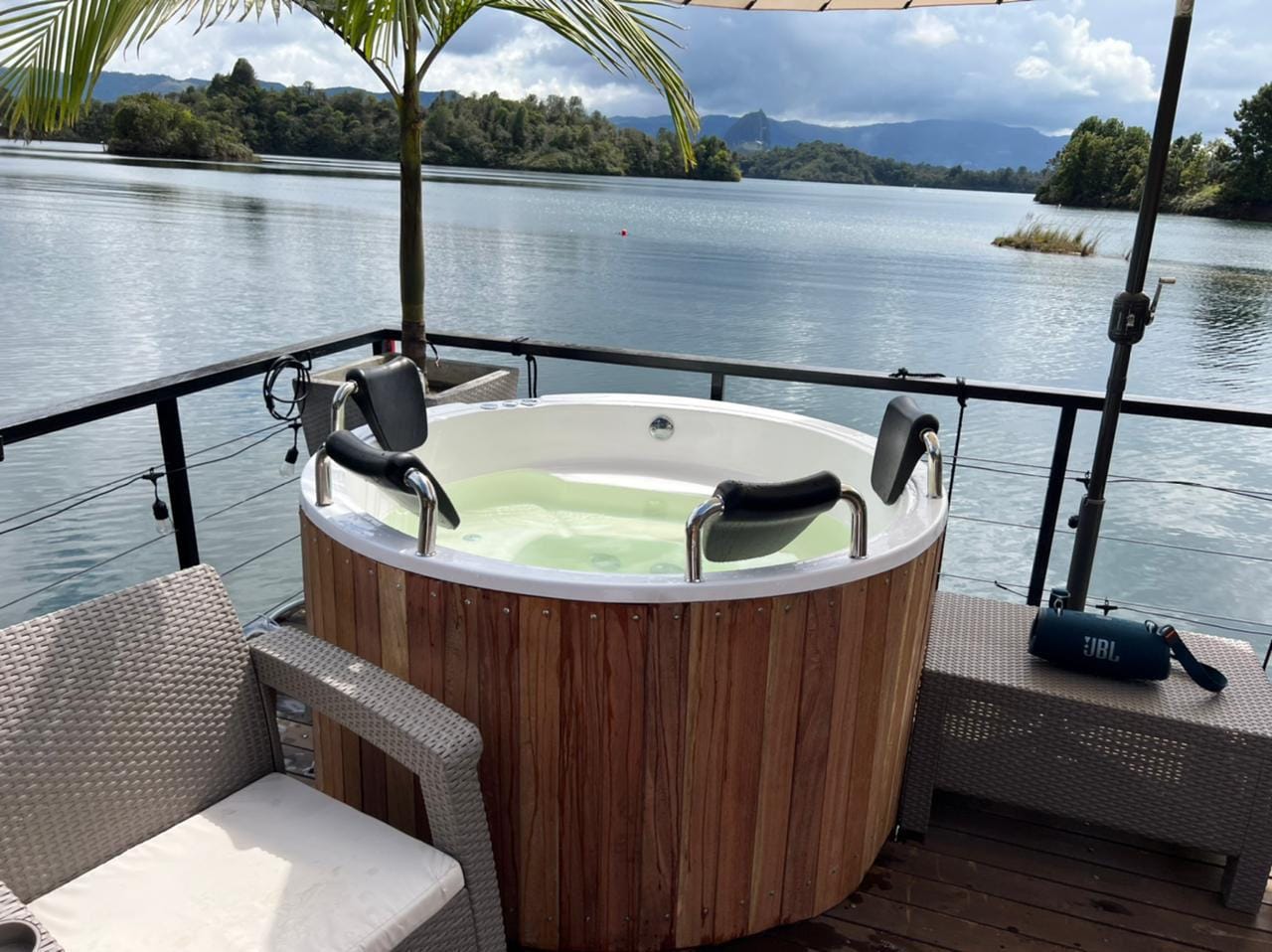 Jacuzzi redondo con revestimiento en madera frente al lago