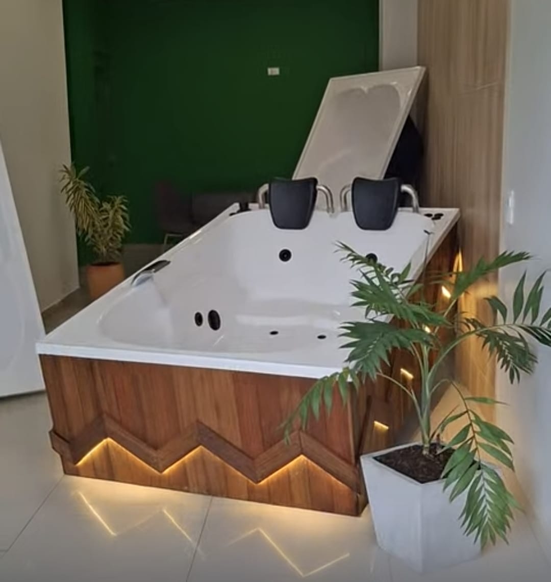 Jacuzzi interior con base en madera e iluminación cálida